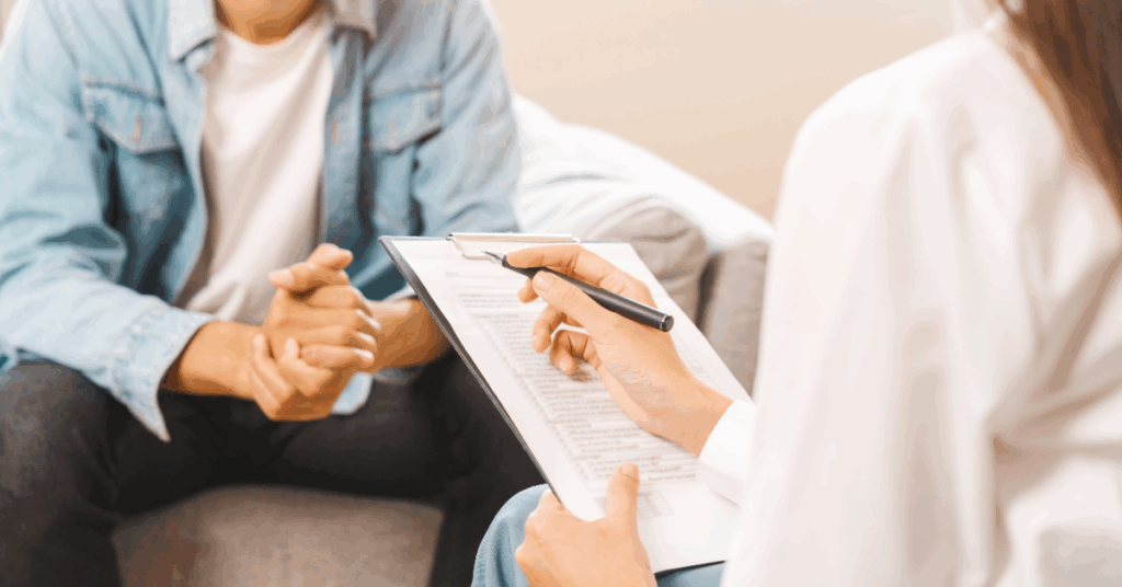 Two people are reviewing and writing on a document together.