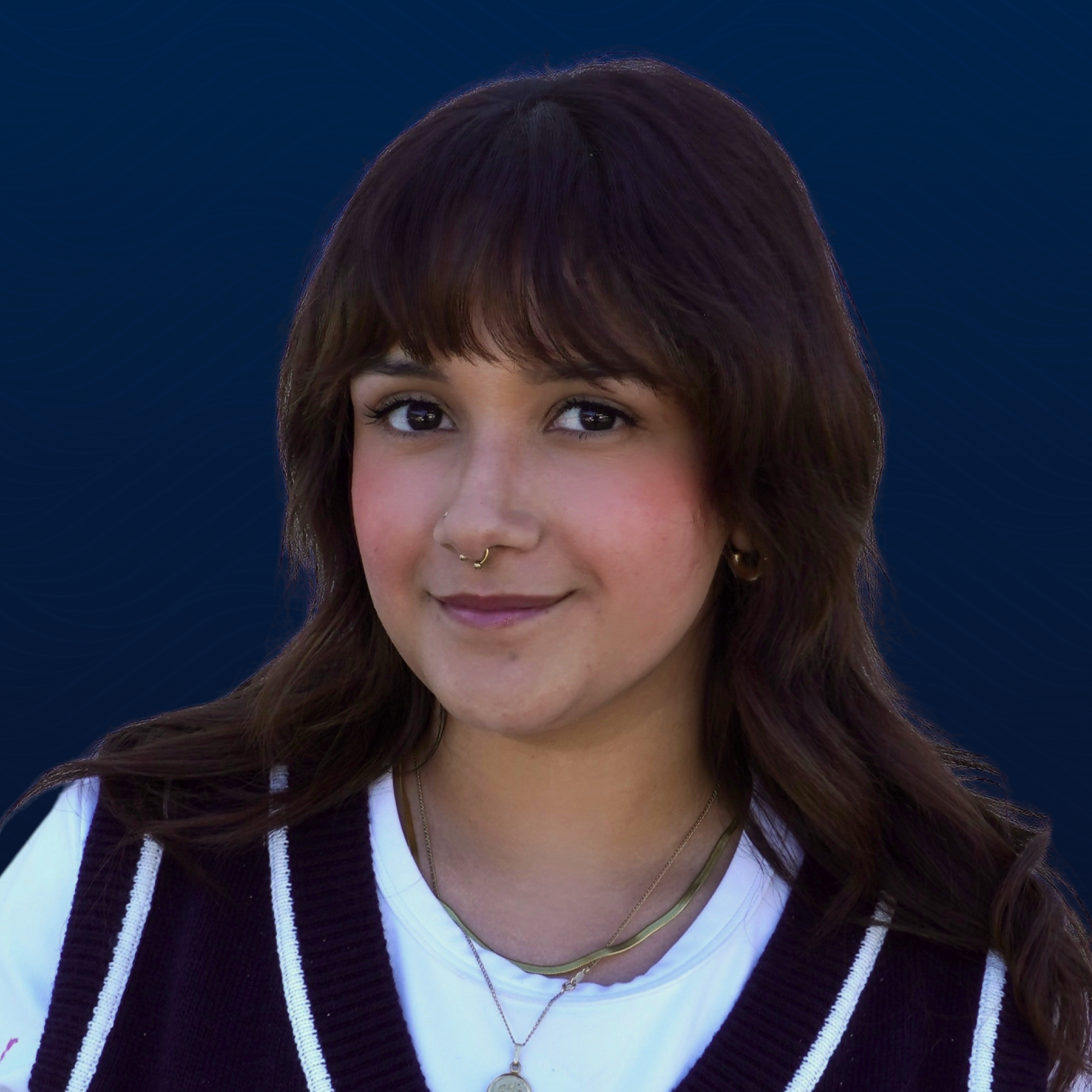 Andrea Quiroz, with long brown hair smiles at the camera.