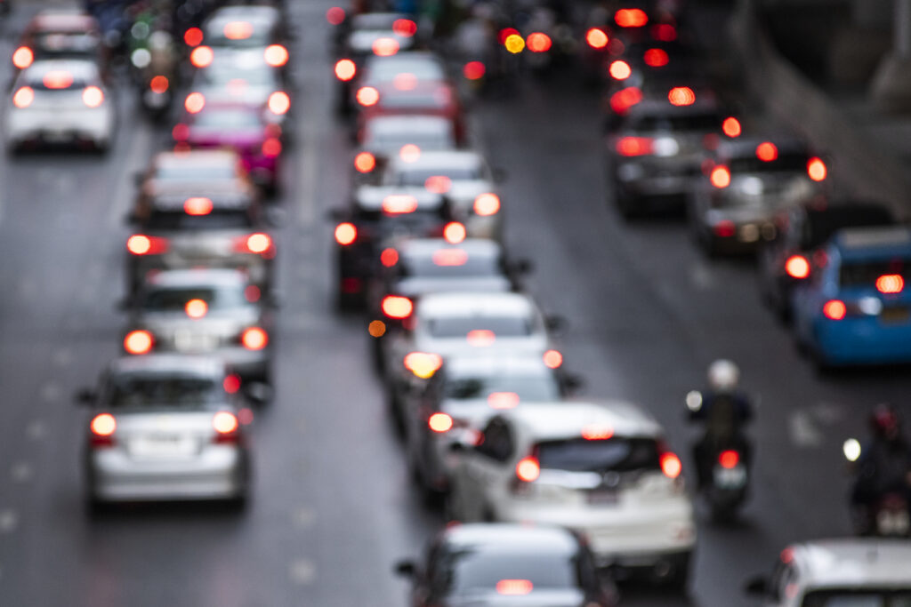 Cars are driving quickly down a blurred road.
