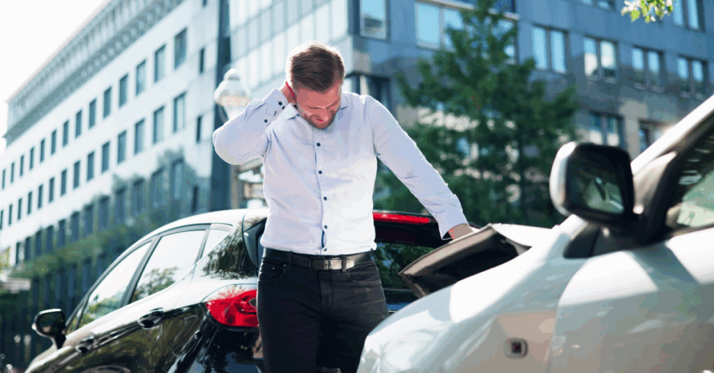 A man leans over the open trunk of a parked car.