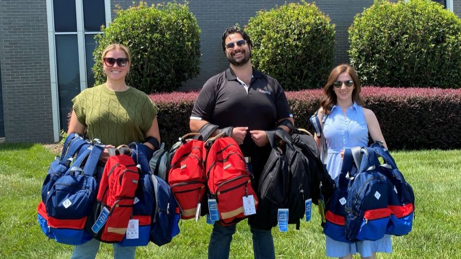 Anslee, Tim and Isabella holding backpacks that Armada Law donated to United Way of Greenville County