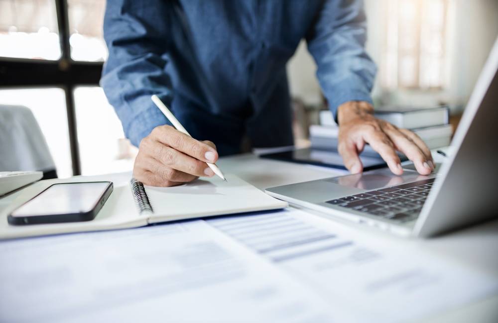 Photo of man working at the desk with laptop