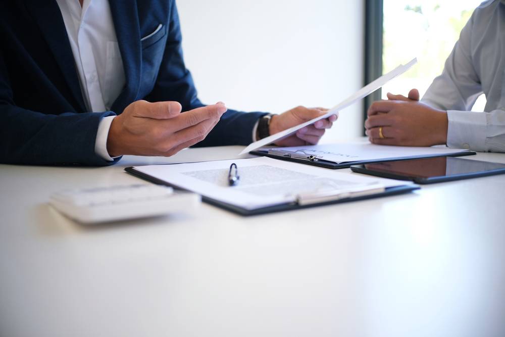 Photo of two man at the desk with papers