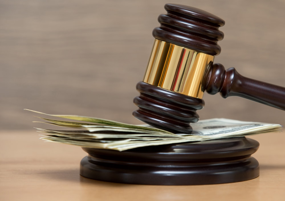 A gavel on desk with dollar bills
