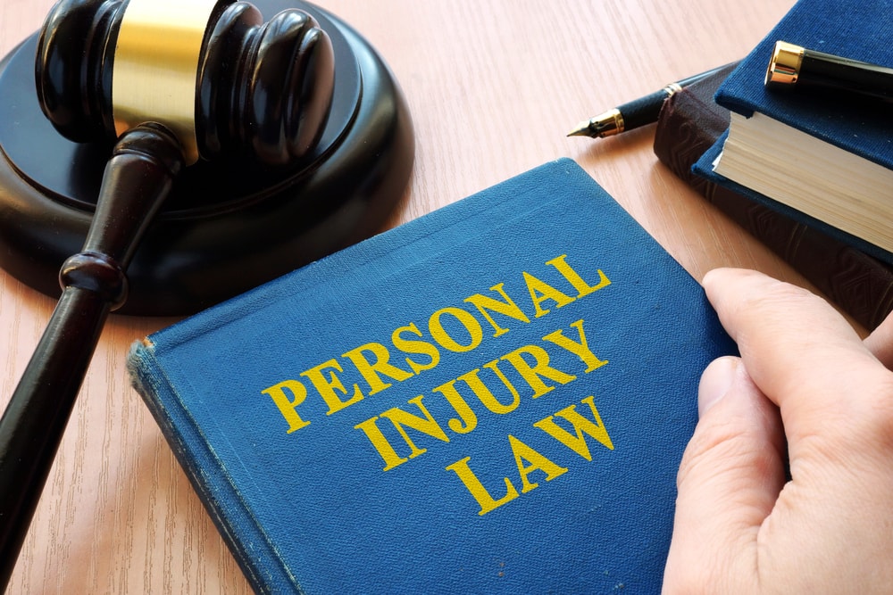 Closeup of the phrase "Personal Injury Law" printed in a book with a gavel in the background