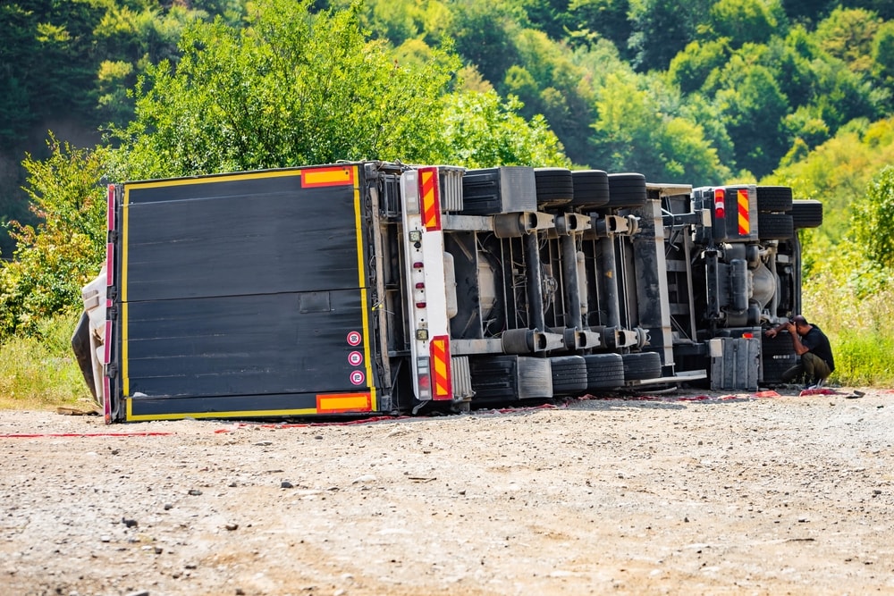 Semi-trailer truck tipped over on a dirt road