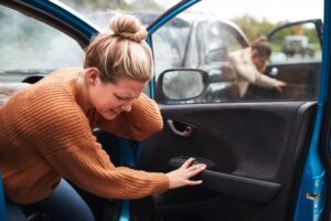 Woman holding her neck and shoulder after car accident