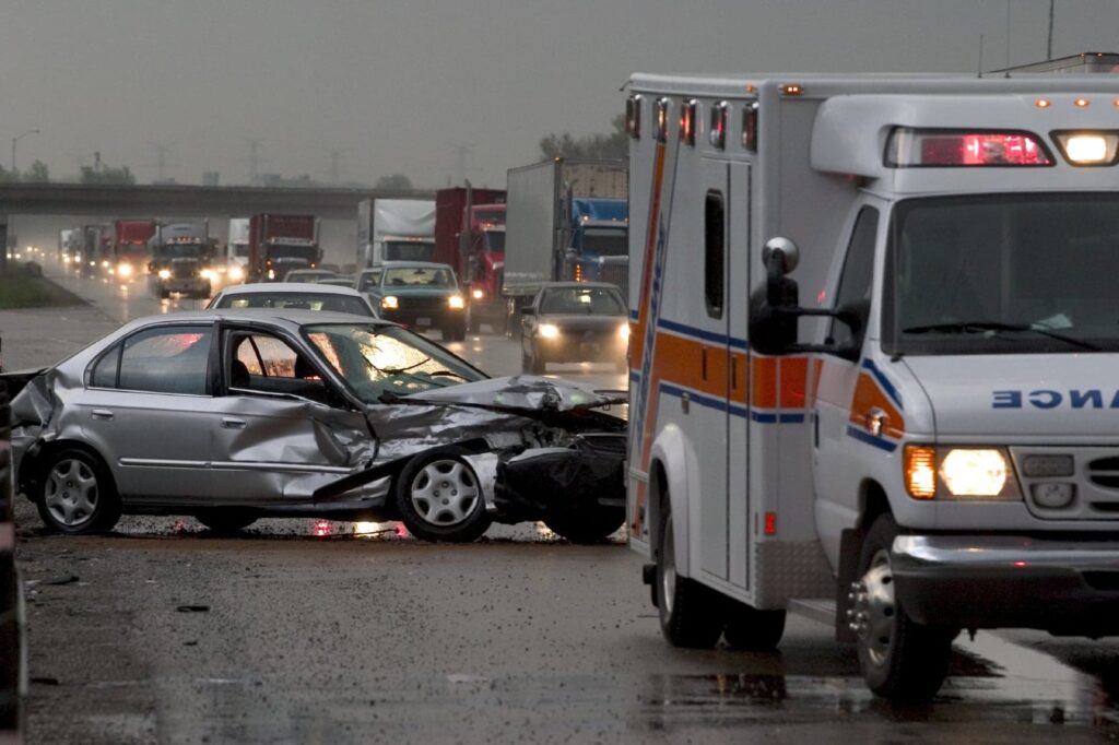 Photo of ambulance and crashed car next to it