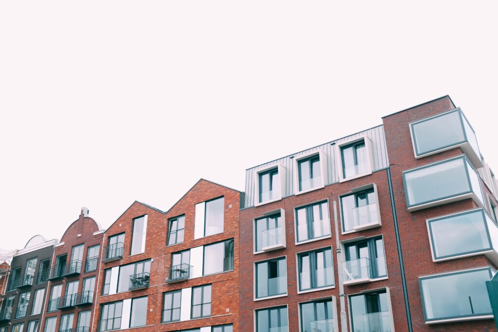 A low angle shot of a concrete brown apartment building under the white sky
